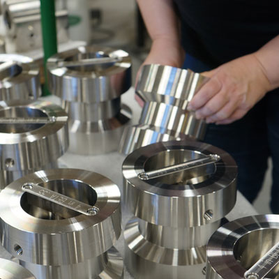 Hands picking up a stainless-steel Wafer-Cone flow meter