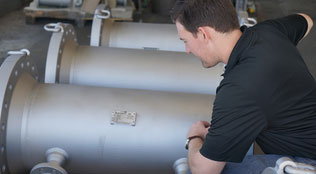 Image of a McCrometer engineer and a custom V-Cone differential pressure flow meter.