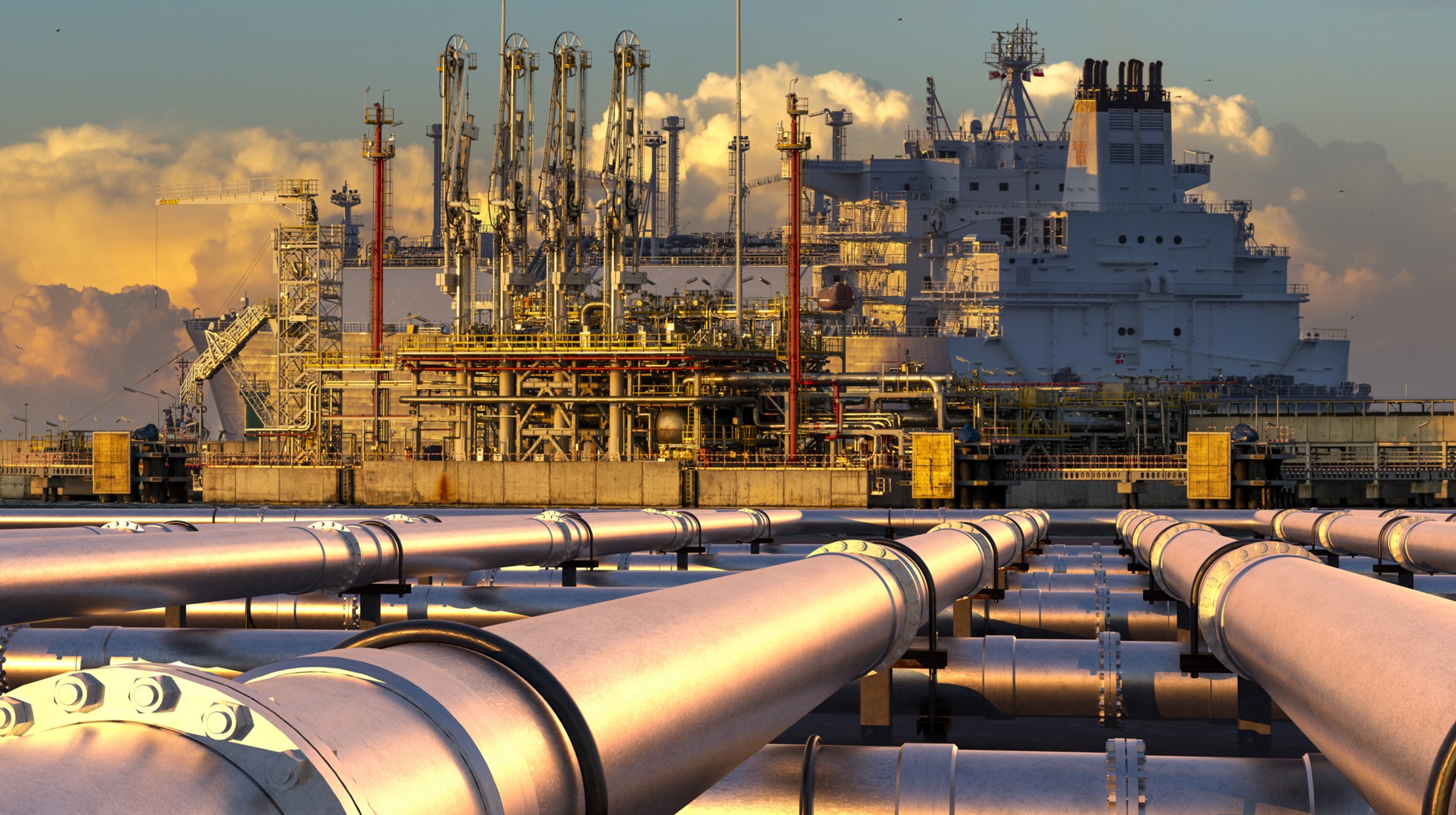A stock image of pipelines and heavy industrial facility in the background