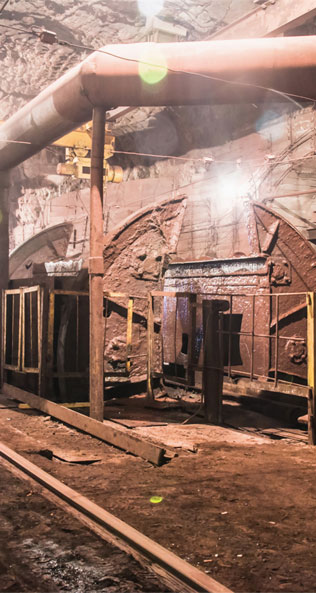 An image of a modern-day, well-lit mine shaft and pipelines.