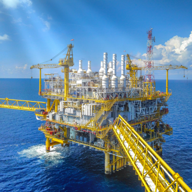 Oil and gas: A yellow oil platform in the middle of a blue ocean.