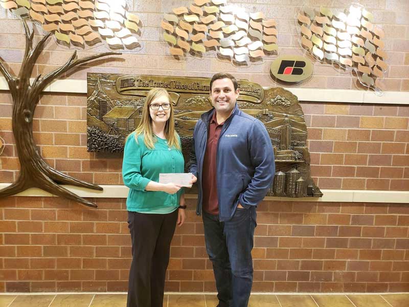 Megahn Schafer, Executive Director of the Nebraska Farm Bureau, receives donation check presented by Rob Collier, President of McCrometer, on April 18th, 2019