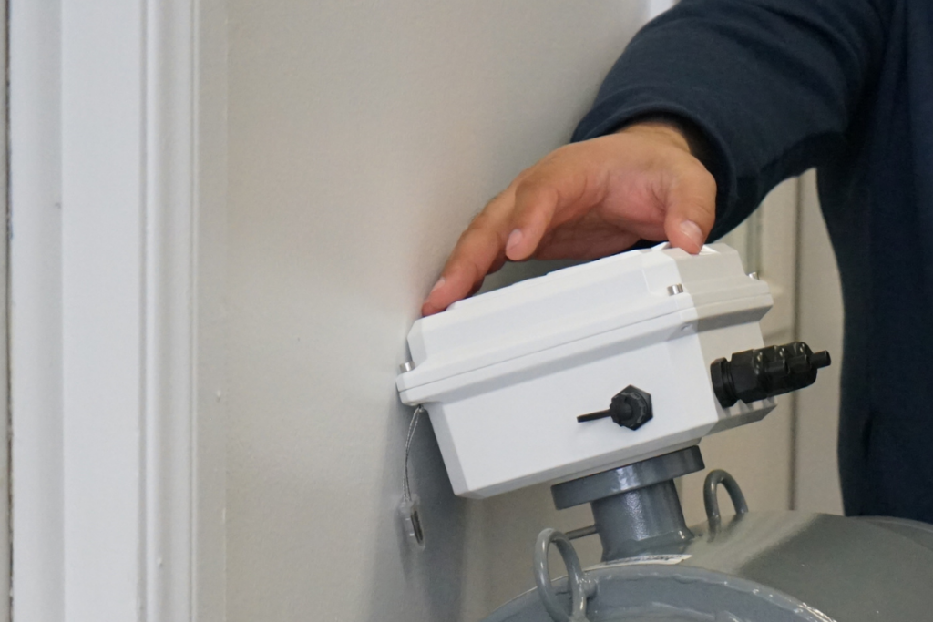 Close-up image of a hand touching the top of McCrometer’s ProComm Go electronics.
